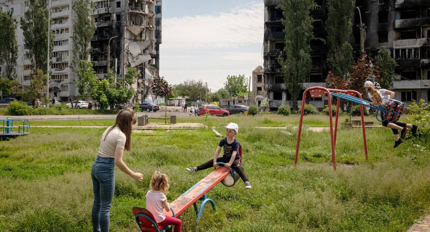 Zdjęcie bawiących się ukraińskich dzieci w Borodjance na Ukrainie na tle zbombardowanych bloków/ Flickr.com/ manhhai