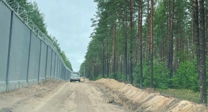 Zdjęcie pojazdu Straży Granicznej pod zaporą oddzielającą od Białorusi/ SG