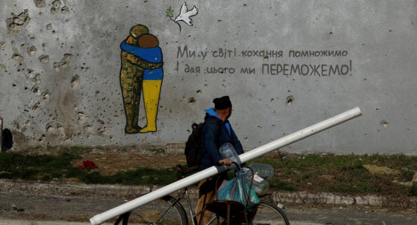Zdęcie mężczyzny na rowerze przy pomalowanym murze na Ukrainie/ Flickr.com  Just Clicks With A Camera