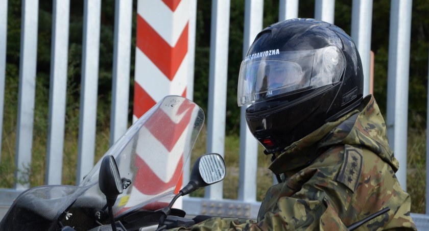 Zdjęcie strażnika granicznego na motorze pod zaporą na granicy z Białorusią/ SG
