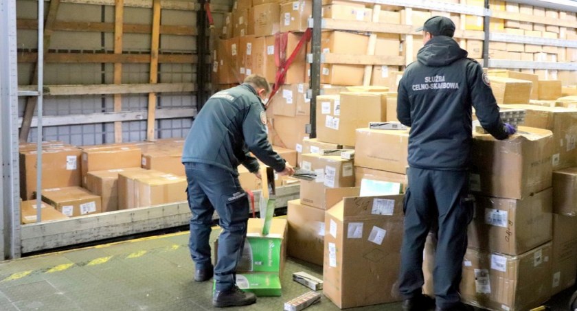 Zdjęcie przedstawia rozpakowywanie kartonów z nielegalnymi papierosami / Foto: KAS