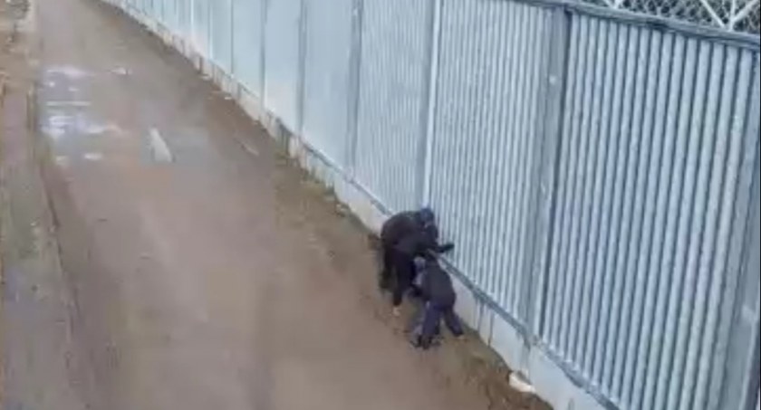 Zdjęcie aktywistów usiłujących przerzucić przedmioty przez zaporę na terytorium Białorusi/ SG