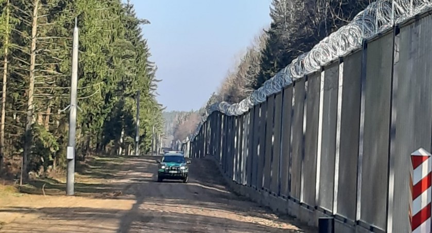Zdjęcie pojazdu Straży Granicznej pod zaporą oddzielającą od Białorusi/ SG