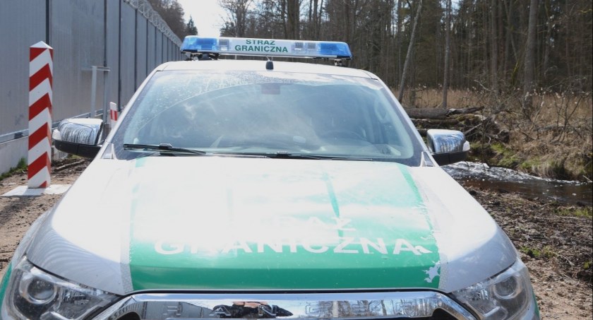 Zdjęcie pojazdu Straży Granicznej pod zaporą oddzielającą od Białorusi/ SG