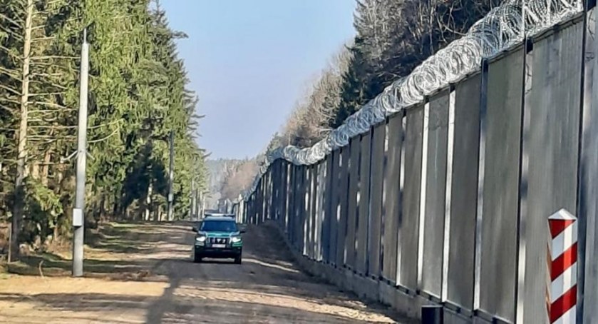 Zdjęcie pojazdu Straży Granicznej pod zaporą oddzielającą od Białorusi/ SG