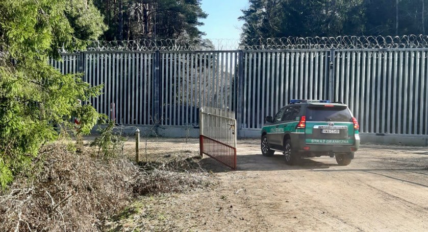Zdjęcie pojazdu Straży Granicznej pod zaporą oddzielającą od Białorusi/ SG