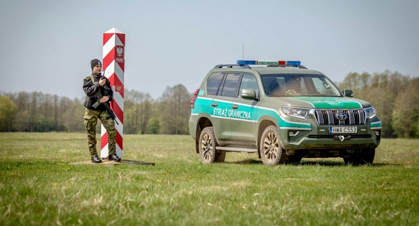 Zdjęcie strażniczki granicznej przy pojeździe służbowym i słupie granicznym/ Twitter.com Straż Graniczna