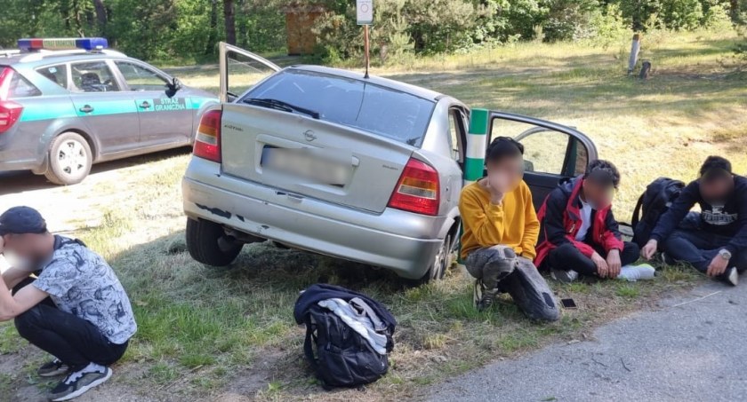 Zdjęcie zatrzymanych nielegalnych migrantów i przewożących ich przemytników/ SG