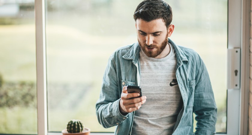 Zdjęcie mężczyzny trzymającego telefon komórkowy