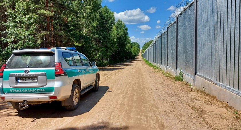 Zdjęcie pojazdu Straży Granicznej pod zaporą oddzielającą od Białorusi/ SG
