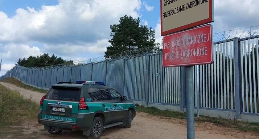 Zdjęcie pojazdu Straży Granicznej pod zaporą oddzielającą od Białorusi/ SG