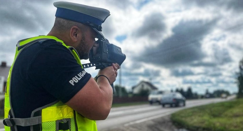 Zdjęcie policjanta drogówki mierzącego prędkość na drodze/ podlaska.policja.gov.pl
