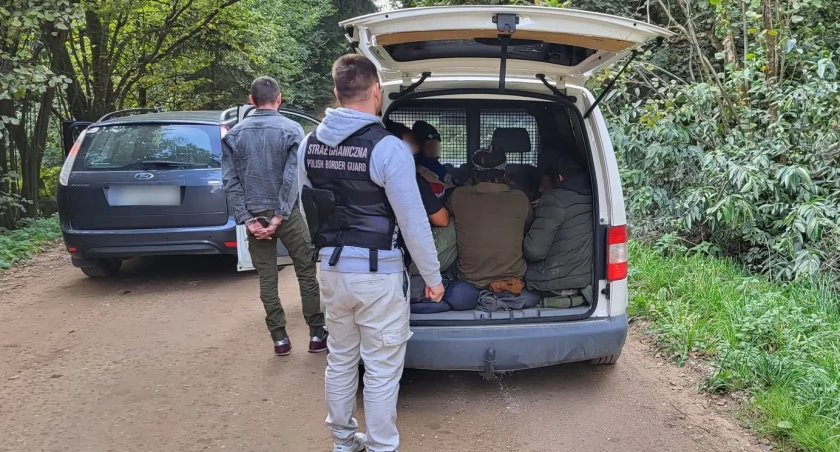 Zdjęcie strażników granicznych z zatrzymanymi nielegalnymi migrantami/ SG