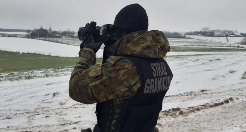 Zdjęcie strażnika granicznego patrzącego przez lornetkę/ Straż Graniczna