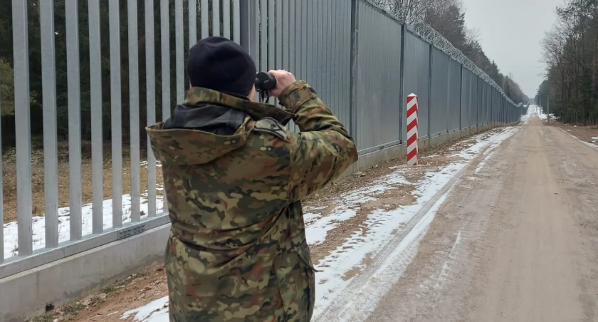 Zdjęcie strażnika granicznego patrzącego przez lornetkę/ Straż Graniczna
