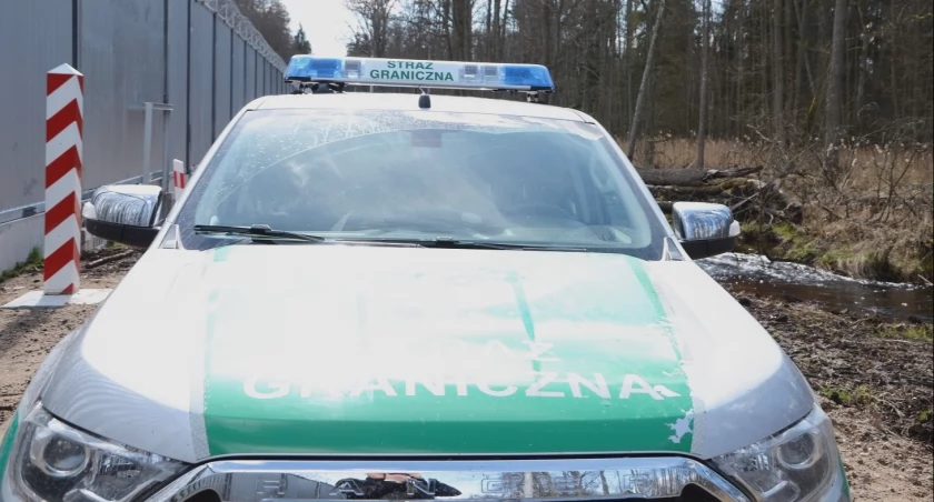 Zdjęcie pojazdu Straży Granicznej pod zaporą oddzielającą od Białorusi/ SG