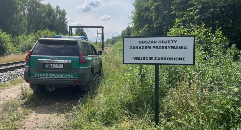Zdjęcie pojazdu Straży Granicznej przy znaku ostrzegawczym o strefie buforowej/ SG