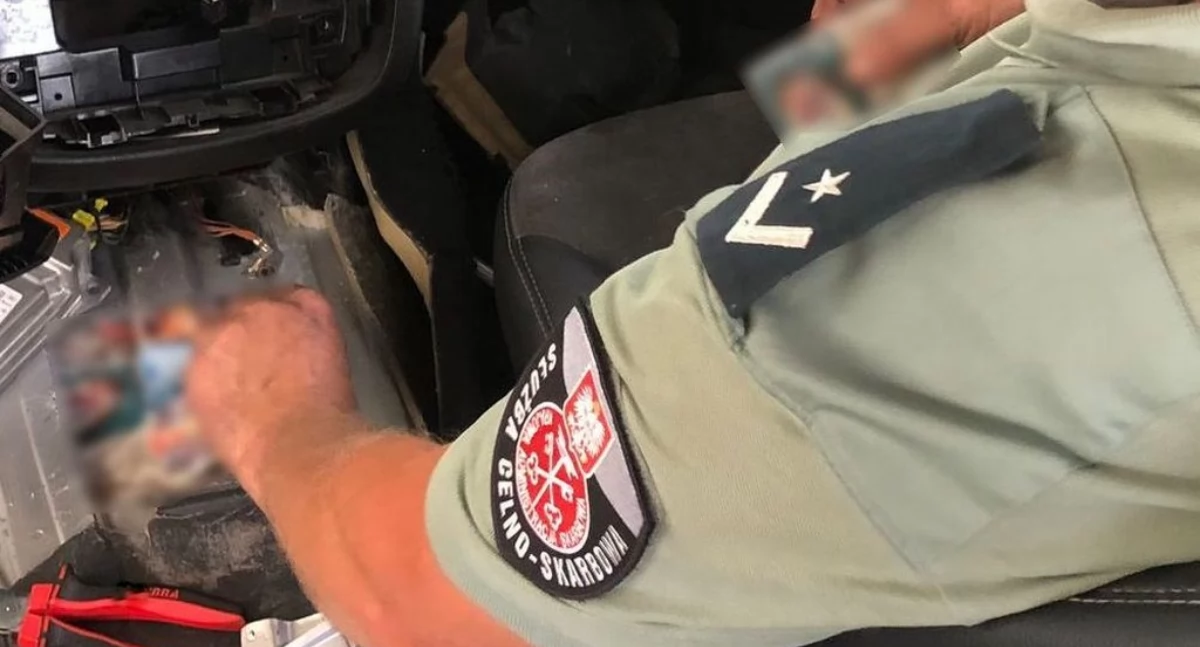 Funkcjonariusz KAS przeszukujący auto / Foto: KAS