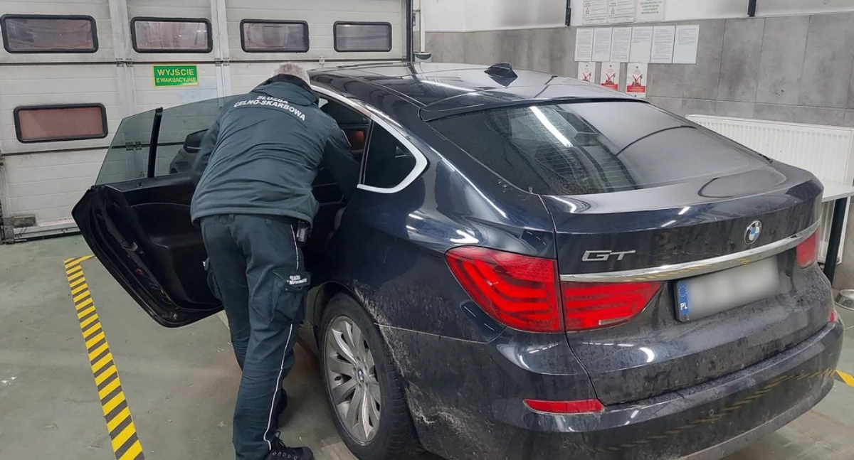 Funkcjonariusz KAS przeszukujący auto / Fot. KAS