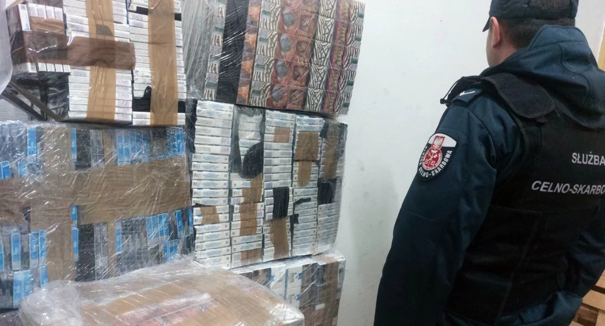 Funkcjonariusz KAS przy zabezpieczonych papierosach / Fot. KAS